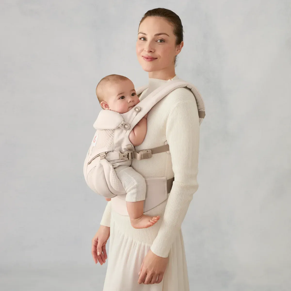 Мать несёт младенца лицом к себе в переноске Ergobaby Omni Classic Mesh цвета Natural Beige