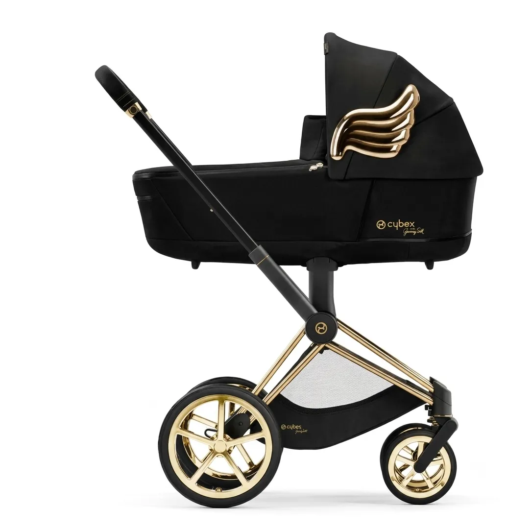 Cybex Priam Wings by Jeremy Scott в профиль: чёрная люлька с золотым крылом на капюшоне, золотое шасси и диски колёс